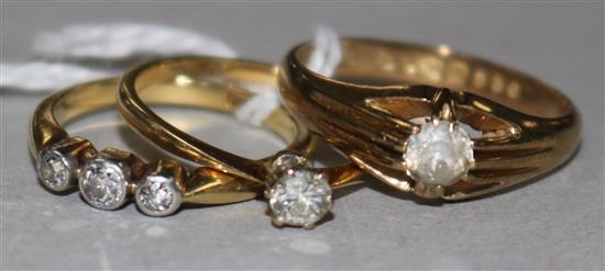 An 18ct gold, platinum and diamond solitaire ring, a similar 9ct ring and an 18ct three-stone diamond ring.